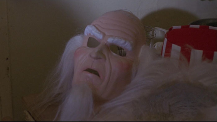 Creepy Uncle Sam mask with white eyebrows and beard lies on a table in a scene from Uncle Sam (1996).