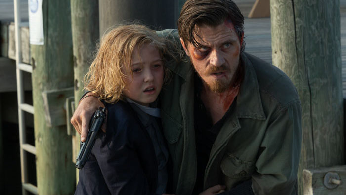 Garrett Hedlund as Caleb holds Christian Convery as Ethan at gunpoint in Barron’s Cove
