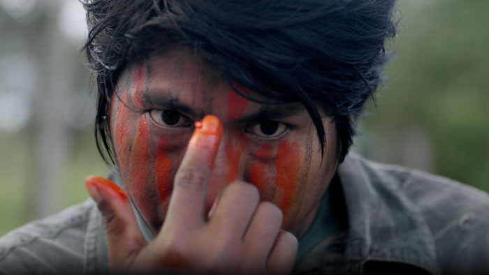 Marçal Guajajara paints his face with red pigment in preparation for a mission