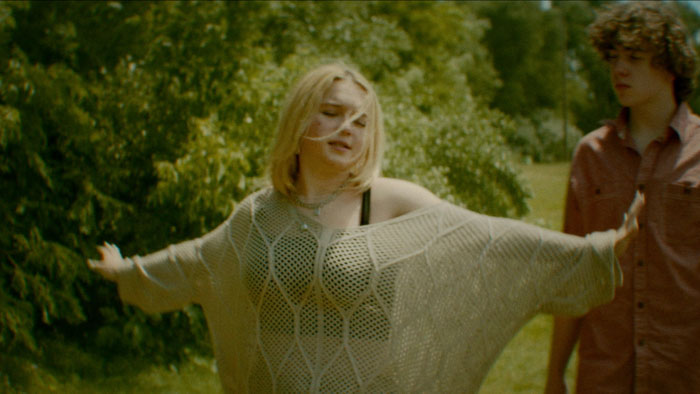 Lennon spreads her arms in a moment of freedom as Roman watches in Inertia.