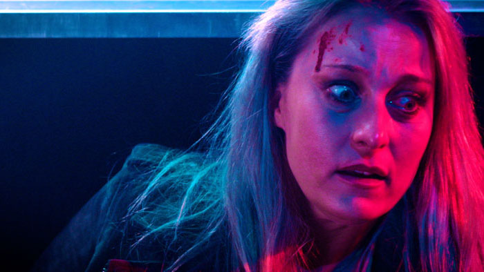 Bloodied woman panics under neon lights in A Hard Place