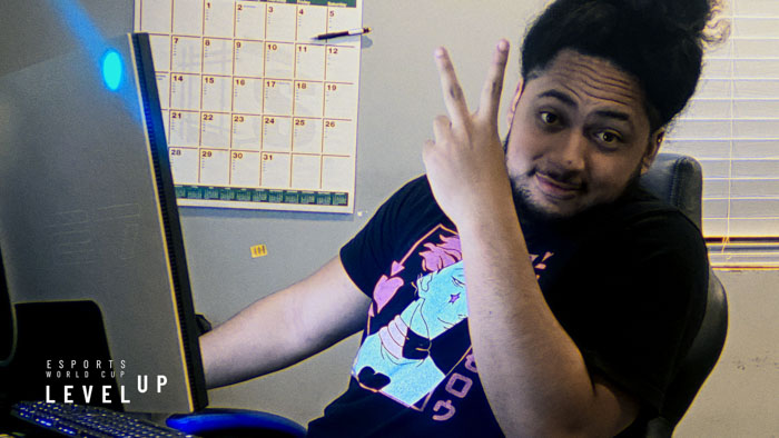 Soka flashes a peace sign at his gaming setup in Esports World Cup: Level Up