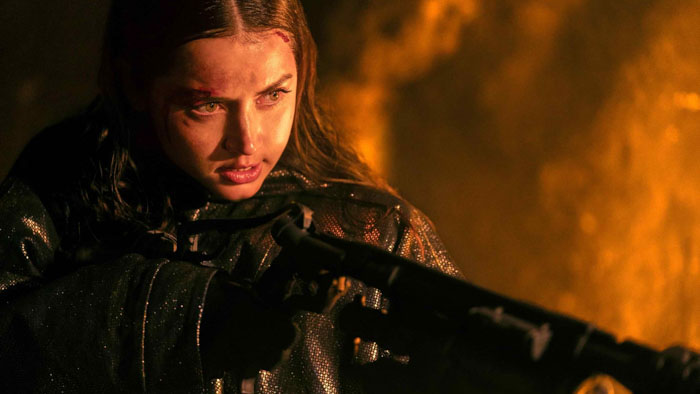Ana de Armas as Eve aiming a shotgun in a fiery action scene from Ballerina (2025)