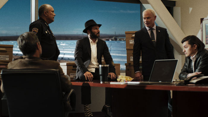 Rabbi Mo confronts city officials and law enforcement in a solar company office.