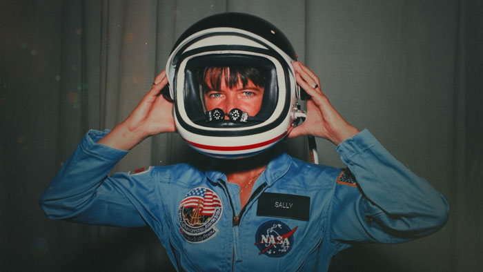Sally Ride putting on NASA astronaut helmet