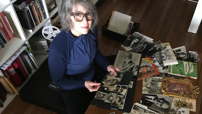 Maria Munro looks through old family photographs and documents on the floor of her study, exploring her family history.