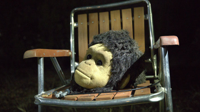 Monkey costume head resting on a lawn chair in Sunlight movie scene.