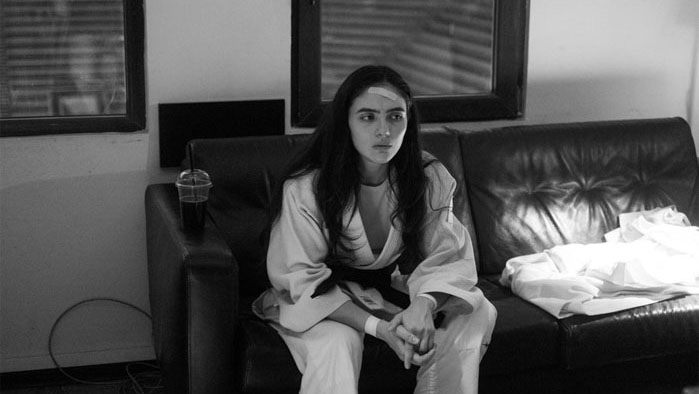 Arienne Mandi as Leila sits in quiet determination in a backstage moment from Tatami