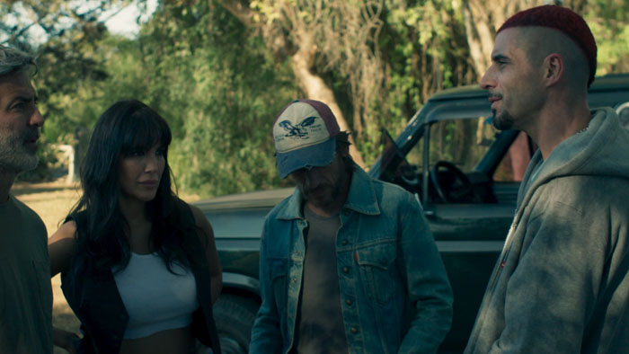 Four members of a rural Argentine heist crew gather beside a pickup truck