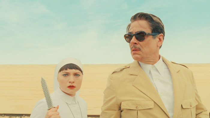 Mia Threapleton and Benicio Del Toro stand in the desert in The Phoenician Scheme.