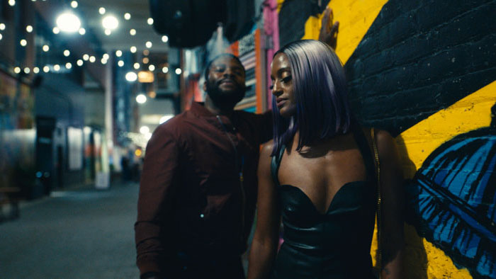 Amin Joseph and Skye P. Marshall walk through a colorful alleyway at night in To Live and Die and Live