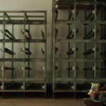 Young boy sits alone on a warehouse floor holding snacks in Without Morals