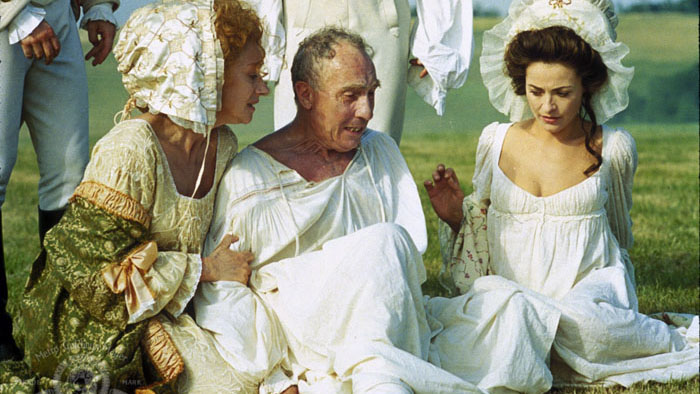 King George III seated on the grass, comforted by two women in period dress from The Madness of King George