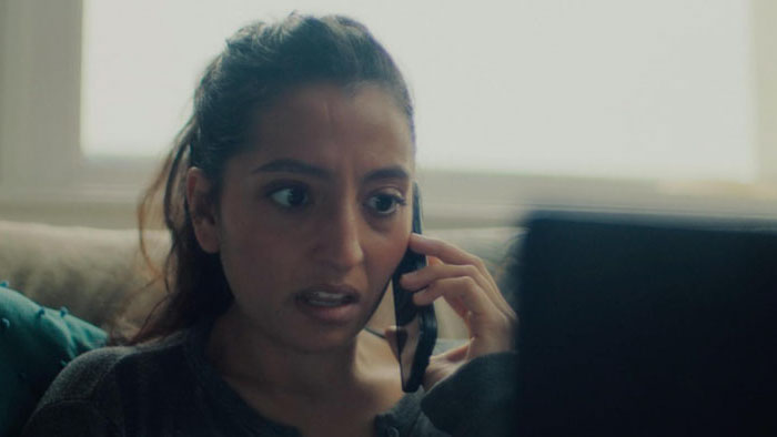 Emma reacts in shock while on the phone in Grave Error.