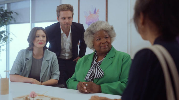 Office meeting scene from the short film Symptoms featuring Eleanor facing three coworkers.