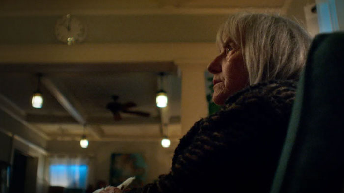 Gladys sits in the shadows, preparing for a dark ritual in Whitch.