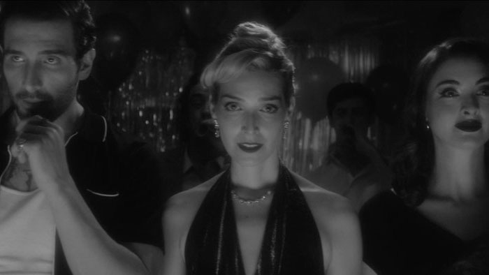 Wolfie (Nick Puya), June (Lexa Gluck), and Dolores (Celia Massingham) stand facing the camera in a tense black-and-white moment from All Us Animals.