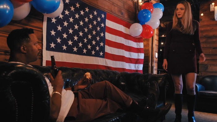 Anna Benoit confronts Rick Younger in front of an American flag in Can’t Let It Go