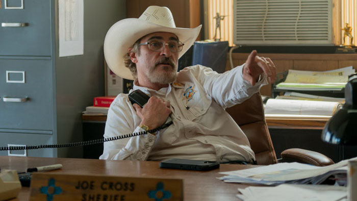 Joaquin Phoenix as Sheriff Joe Cross talking on a phone in his office