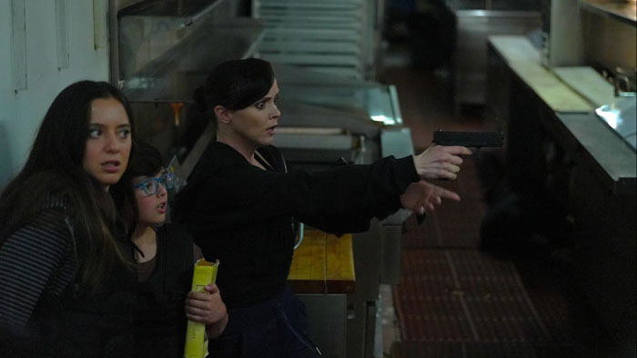 Christina Ricci holds a gun while protecting her children in Guns Up