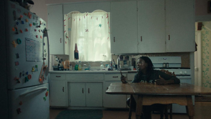 Hannan Younis sits at a kitchen table in the short film Halfway Haunted.