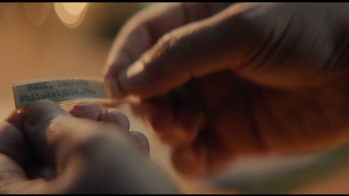 Close-up of hands holding a bracelet tag with adoption details
