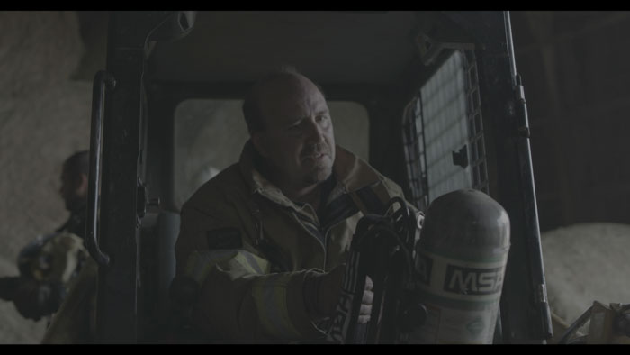 Volunteer firefighter Steve Cross prepares equipment in a rescue vehicle