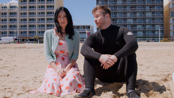 Natalie Veater and Chris Maher sitting on the beach in Boardwalk Winter