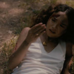 Bernice lies on the forest floor, bloodied and looking at her hand in American Clay.