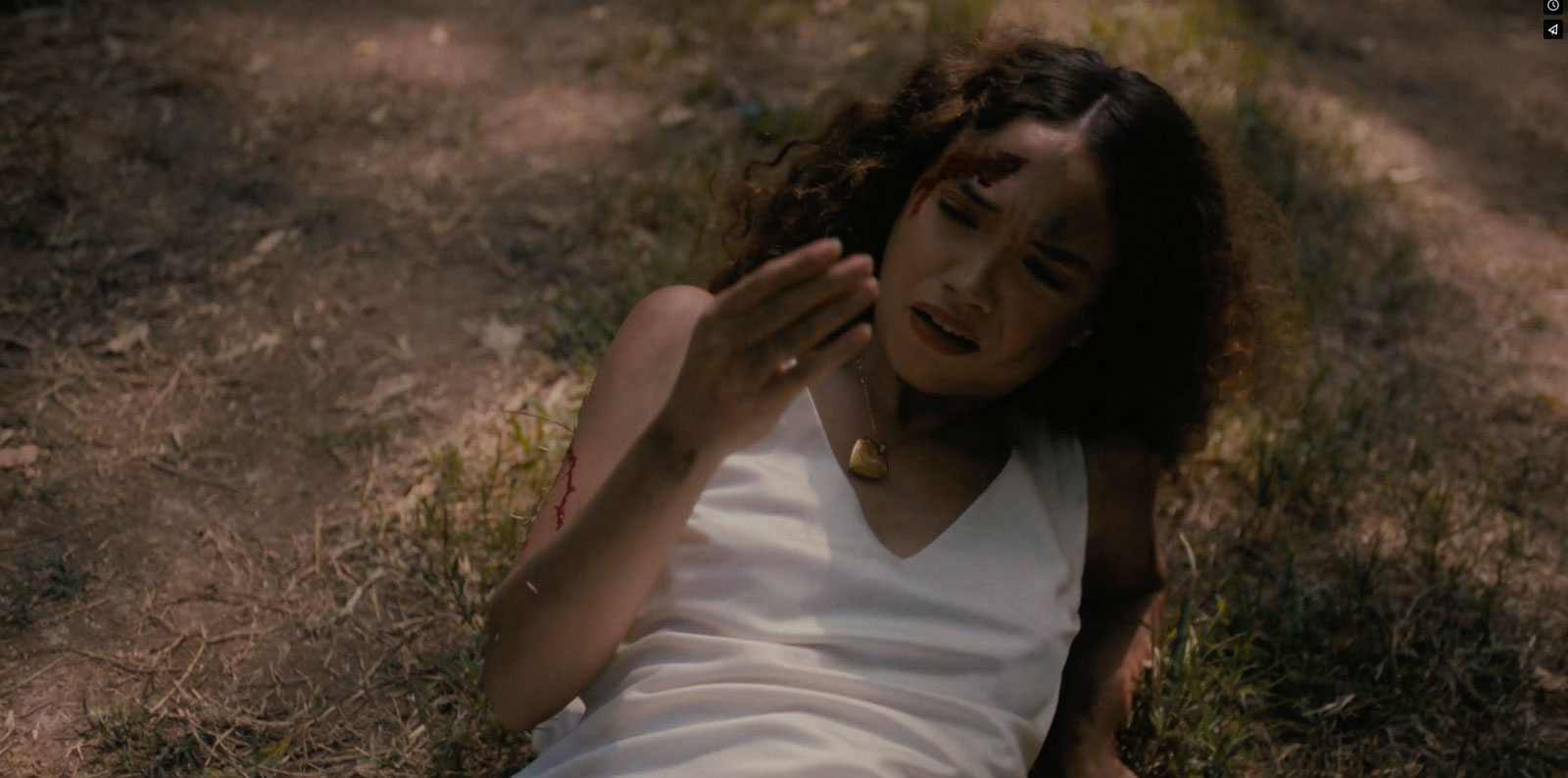 Bernice lies on the forest floor, bloodied and looking at her hand in American Clay.