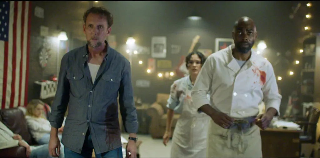 Reynolds, Medina, and Eric stand in the safe room during a tense moment in American Deadbolt.