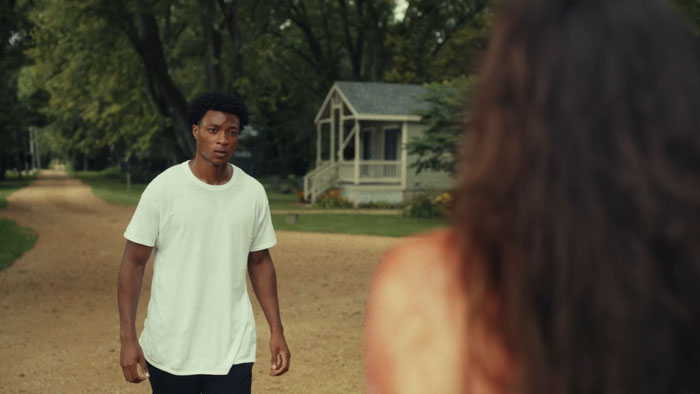 Malachi approaches a mysterious, bloodied woman standing in the street.