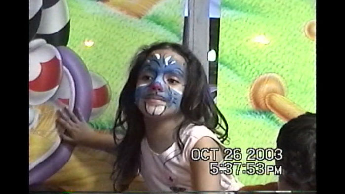Young Geovana Pimentel with face paint captured on family video camera in 2003
