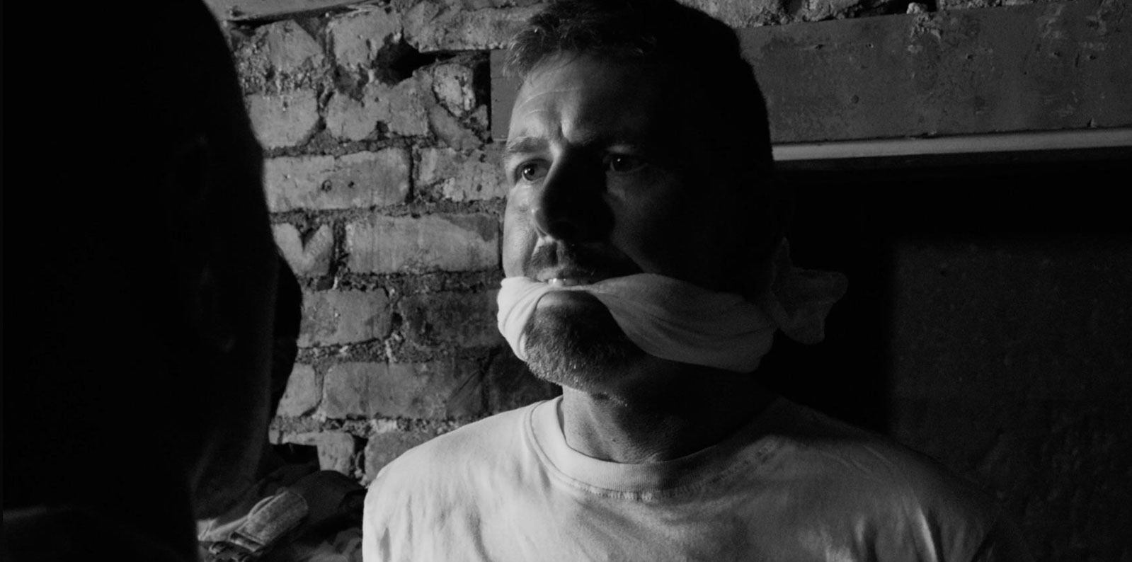 A captive soldier gagged and facing interrogation in Traitor.