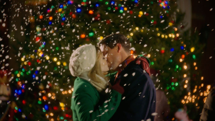 Tom and Annie share a kiss in front of the Christmas tree in A Chrismystery