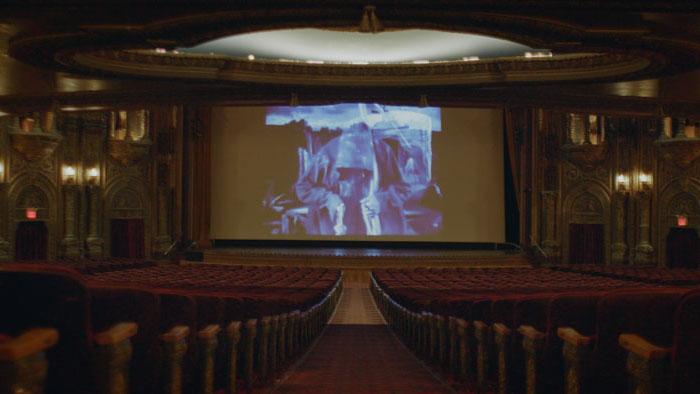Movie still from Capio showing a projection in an ornate theater