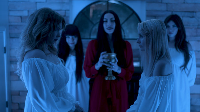 A ritual ceremony scene from Only Fangs with vampires gathered in blue lighting. 
