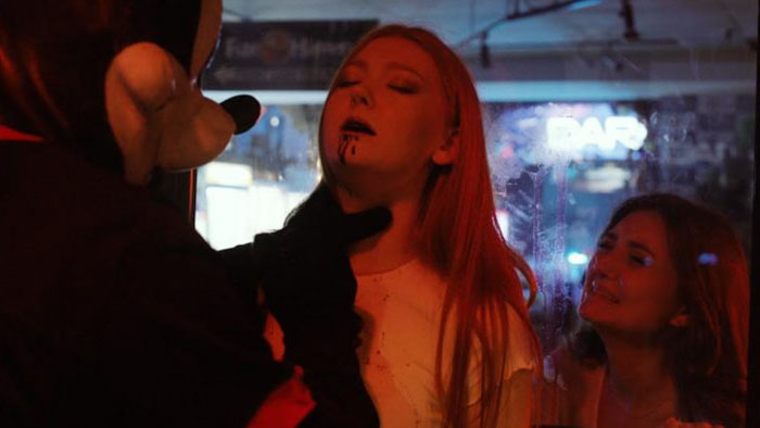 The Mickey Mouse–masked killer attacks a woman inside an arcade in The Mouse Trap.