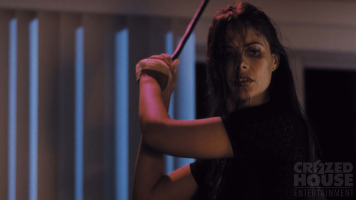 Marisol Padilla Sánchez holding a weapon in a tense scene from Transference.
