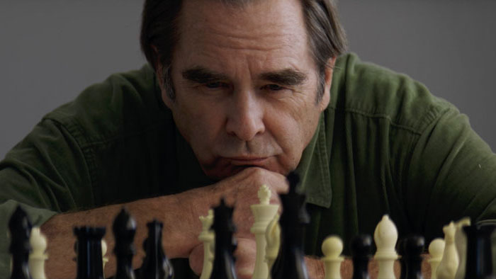 A woman sits alone in quiet reflection in a scene from the film Blue Eyed Girl (2025)