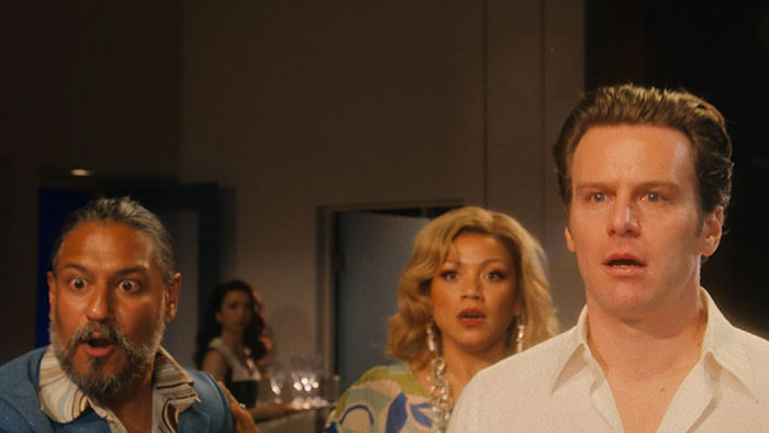 Jonathan Groff and Krystal Joy Brown react during a tense party moment in Merrily We Roll Along (2025).