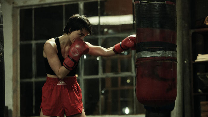 Toni (Luiii) trains on a heavy bag in the boxing gym in Uppercut (2025).