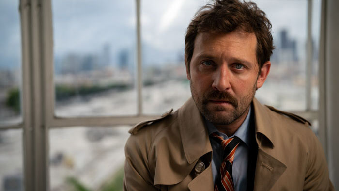 Casen Pointe (Anthony Guerino) in a trench coat at a crime scene in Casen Pointe: True Crime Detective (Episode 101).