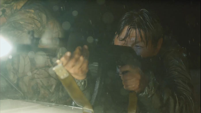 Innokenty Lukovtsev aiming a gun in heavy rain in Stepan Burnashev’s Yakuti thriller Aita (2022)