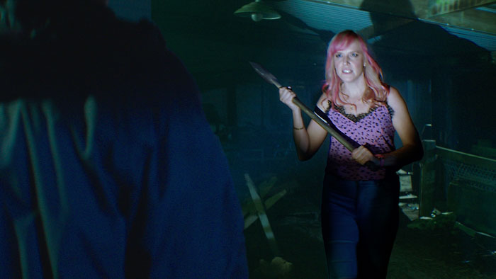 Magda (Melissa De Mol) holding an axe in a confrontation scene from Gone to Ground (2026) 