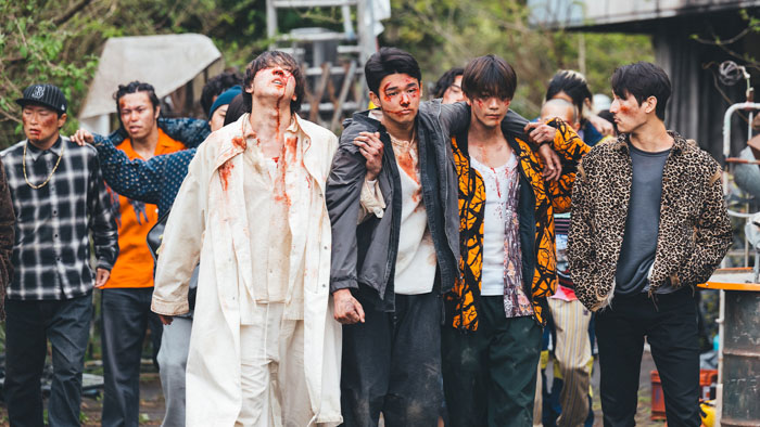A battered group of young fighters walks through a street confrontation in Blazing Fists.
