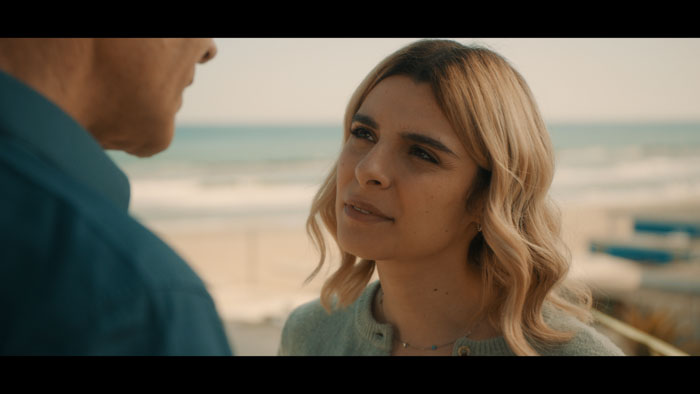 Luce (Alexia Cozzi) speaks to a man by the beach in Blue.