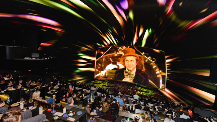 Audience watching Willy Wonka in Cosm’s 87-foot 12K LED dome Shared Reality immersive theater experience