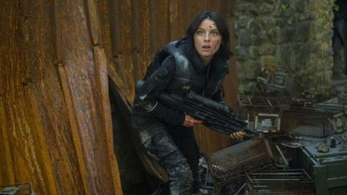 A frightened armed survivor hides during a drone attack in DRAGN. 