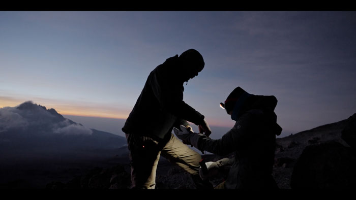 Mandy Horvath preparing during an early morning climb on Mount Kilimanjaro in The Ascent.